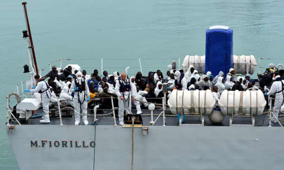 Rescued migrants wait before disembarking off the Italian Guardia Costiera vessel Fiorillo at the Sicilian harbour of Catania.