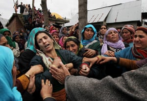 Srinagar, India Kashmiri women try to comfort Zareena during the funeral of her husband Mohammad Shafi, an Indian policeman, who was killed in a gunfight with militants