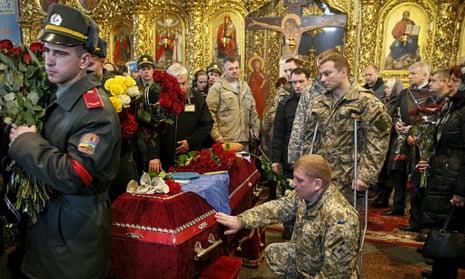 Ukrainian soldiers and coffin of comrade