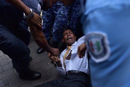 Maldives police try to move former president Mohamed Nasheed as he arrives at court in Male.