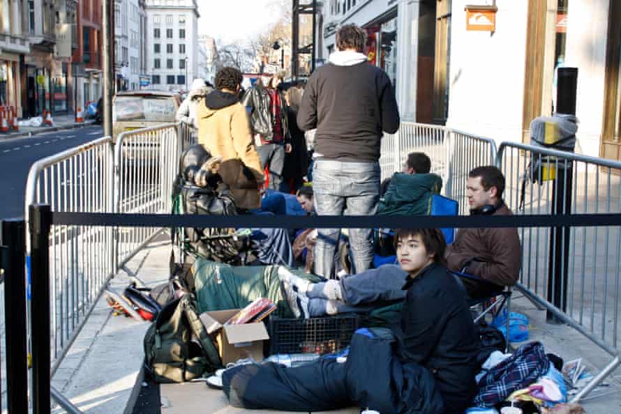 People wait in line outside the Apple store