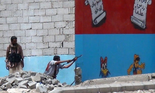 A Yemeni fighter opposing the Houthi rebels fires his weapon in Aden as clashes continue.