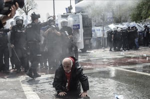 <strong>Istanbul, Turkey </strong>An elderly man attempts to get up off the ground near a row of riot police after Turkish police use a water cannon to disperse protestors during a May Day rally near Taksim Square