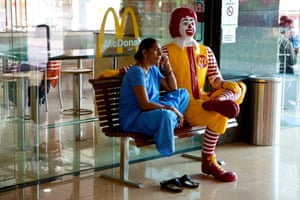 Woman sitting on bench at McDonald's fast food restaurant, Varanasi, Uttar Pradesh, India.