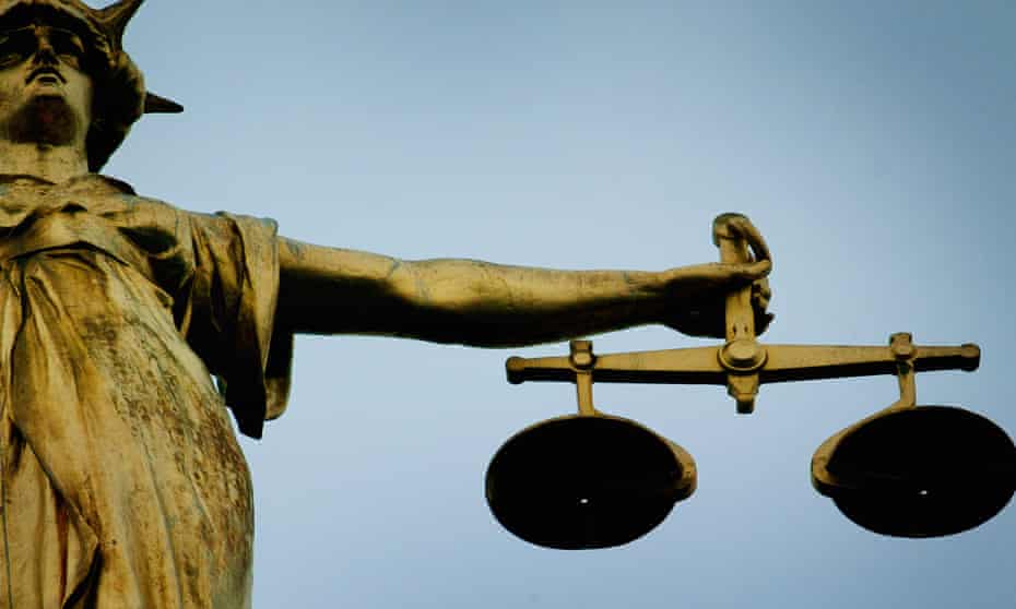 A statue holding the scales of justice is seen on top of the Old Bailey 