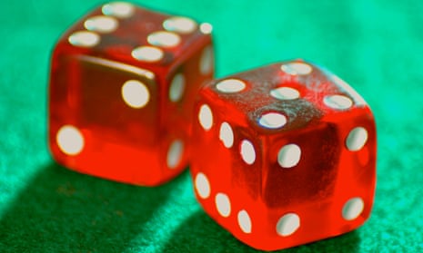 A pair of casino red dice on a green casino table.  Luckwarmers effectively want to bet our future on the dice coming up showing snake eyes.