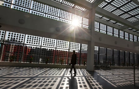 A man walks in a building with solar panel glass windows in the Sino-Singapore Tianjin Eco-city in Tianjin Binhai New Area, China, 30 November 2011.