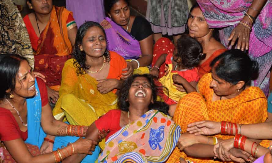 An Indian widow (C) is comforted by relatives and friends after the death of her husband on the outskirts of Patna.