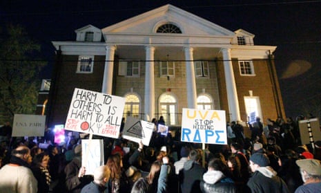 Protestors carry signs and chant slogans in front of the Phi Kappa Psi fraternity house at the University of Virginia, Saturday night, November 22, 2014, in Charlottesville, Virginia. UVA dean Nicole Eramo filed suit on Tuesday, claiming that the article that initiated the protests was malicious and defamatory.