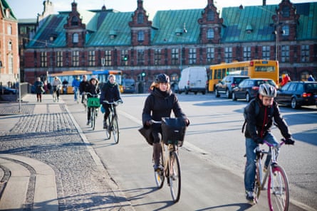 Cyclists use a cycle lane to travel past the Copenhagen Stock Exchange, center, in Copenhagen, Denmark