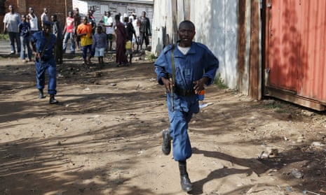 Men in police uniforms walk along a street in Bujumbura, Burundi, on Friday
