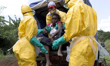 Health workers and a patient in Guinea, November 2014. Experts said the WHO dragged its feet over declaring Ebola a public health emergency.