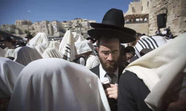 Des hommes juifs drapés dans des châles de prière effectuent la prière des Cohanim (bénédiction du prêtre) pendant la fête de Pessah (Pâque) au Mur occidental dans la vieille ville de Jérusalem.'s blessing) during the Pesach (Passover) holiday at the Western Wall in the old city of Jerusalem.