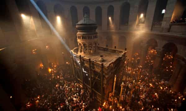 Des pèlerins chrétiens tiennent des bougies à l'église du Saint-Sépulcre de Jérusalem, traditionnellement considérée comme le lieu de sépulture de Jésus-Christ.'s Church of the Holy Sepulchre, traditionally believed to be the burial site of Jesus Christ.