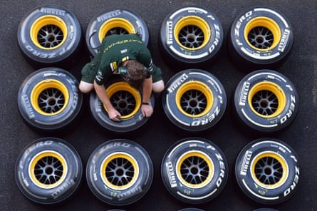A Lotus F1 team mechanic marks wheels with Pirelli tyres