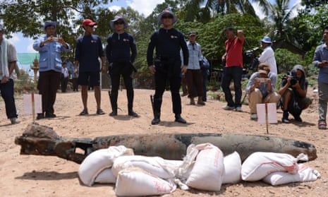4387 - Standing in their scuba gear, UXO recovery divers Lorn Sarat (left) and Sok Chenda stand behind a US-manufactured Mark 82 aircraft bomb, which they salvaged from the Mekong River in Cambodia's Kandal province on May 21, 2015. Two years ago, neither man could swim.