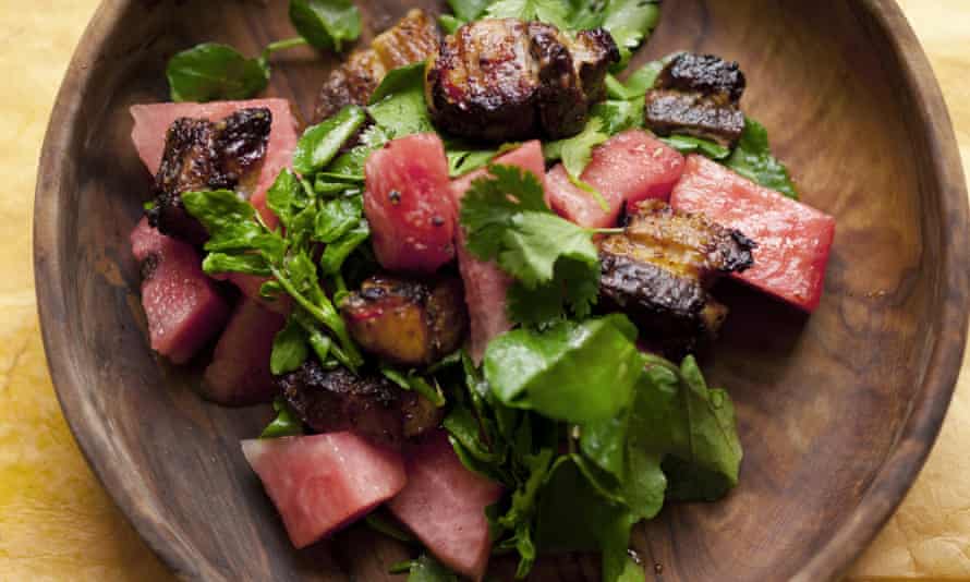 Spiced pork and watermelon salad in a wooden bowl