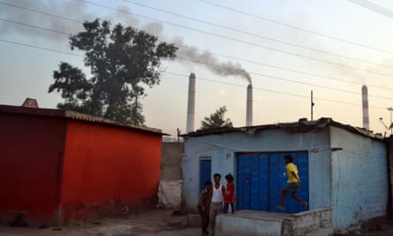 Children play out side their houses in 
Vindhyanagar, Madhya Pradesh, while smoke belches out of the power station nearby.