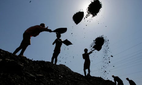 Labourers load coal on trucks 
