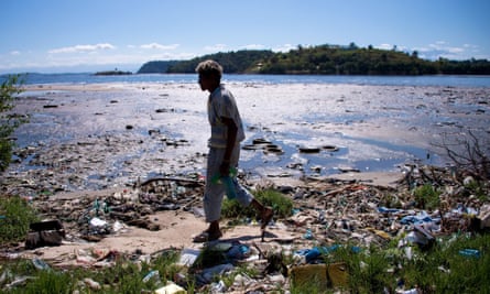 A man walks along the shoreline of the polluted waters of Guanabara Bay near Rio de Janeiro.