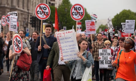 Anti-austerity protesters march down Whitehall during a demonstration on Wednesday after the state opening of parliament.