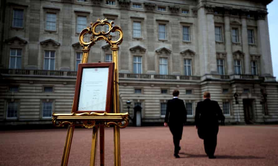 Two workers return to Buckingham palace after placing an easel in the forecourt to announce the birth of a baby girl to the Duchess of Cambridge.