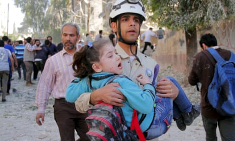 A civil defence worker rescues a schoolgirl after what activists said was a barrel-bomb attack by forces loyal to Syria's president Bashar al-Assad in Aleppo.