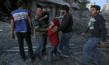 A family amid wreckage in the wake of an attack in Aleppo on Friday.