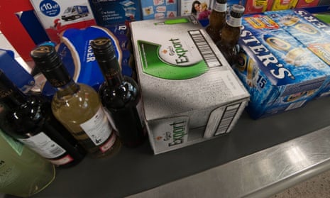 Beer and bottles of wines and spirits on a supermarket checkout belt - branch of Tesco Galashiels Scotland.
