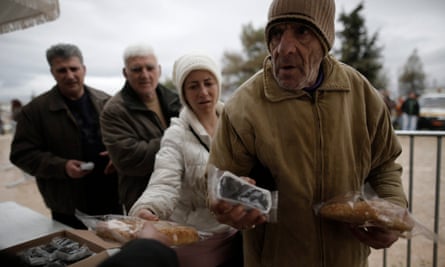People receive olives and bread distributed for free by municipality of Athens in February. After three months of fruitless talks, Greek public finances have never been worse.