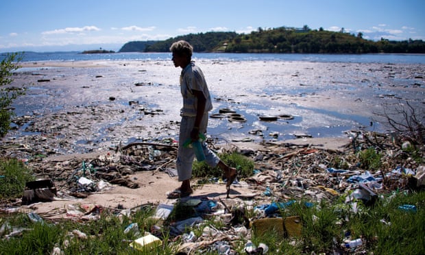A man walks along the shoreline of the polluted waters of Guanabara Bay near Rio de Janeiro. The iconic bay will be the site of sailing events during the 2016 Olympic Games.