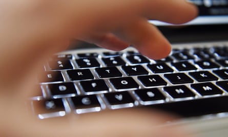 A hand operates above a laptop’s keyboard in London, Britain.