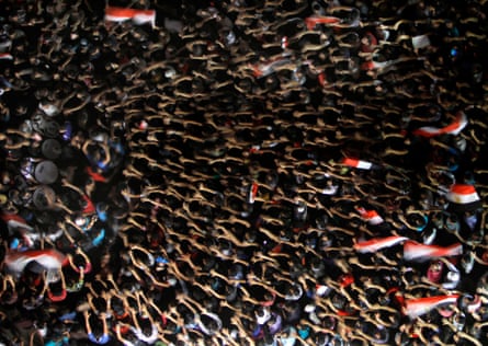 Egyptian protesters wave their hands and hold national flags during anti-President Mohammed Morsi demonstration in Tahrir Square in Cairo on June 28, 2013.