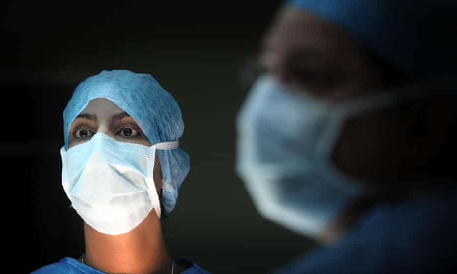 A surgeon and his theatre team perform an operation.