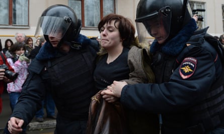 Russian police officers detain an opposition activist outside a court in Moscow.