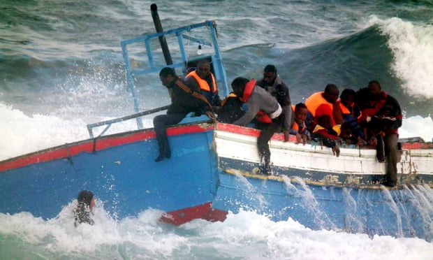 Rescuers help stranded coming from Libya from a boat that crashed into rocks as they tried to enter the port of Pantelleria, an island off the southern coast of Italy.