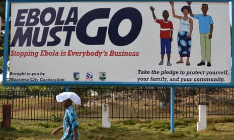 A man walks past an ebola campaign banner in Monrovia.