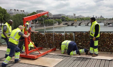 Workmen remove iron grills covered with "love locks" on the Pont des Arts.