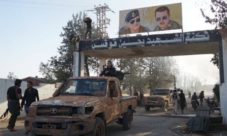 Posters of Syrian president Bashar Al-Assad and his father Hafez Al-Assad are seen at the main entrance at the Brigade 52 military base after it was captured by the Free Syrian Army in Daraa.