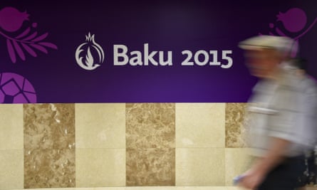 A man passes a banner promoting the 2015 European Games in Baku.