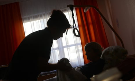 nurse helping an older woman in a nursing home
