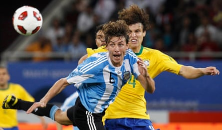 Argentina's Gabriel Heinze heads the ball away from Brazil's David Luiz during the friendly in Doha.