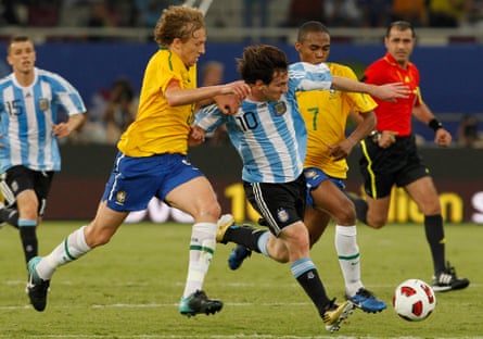 Lionel Messi takes the ball away from Brazil's Lucas Leiva in Doha, Qatar.
