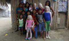 Four albino sisters, from L-R, Iveily, Donilcia, Jade and Yaisseth Morales, who are part of the albino or "Children of the Moon" group in the Guna Yala indigenous community, pose for a photograph with their mother, brothers and sisters outside their house on Ustupu Island in the Guna Yala region, Panama