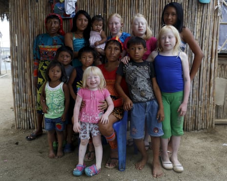 Four albino sisters, from L-R, Iveily, Donilcia, Jade and Yaisseth Morales, who are part of the albino or "Children of the Moon" group in the Guna Yala indigenous community, pose for a photograph with their mother, brothers and sisters outside their house on Ustupu Island in the Guna Yala region, Panama