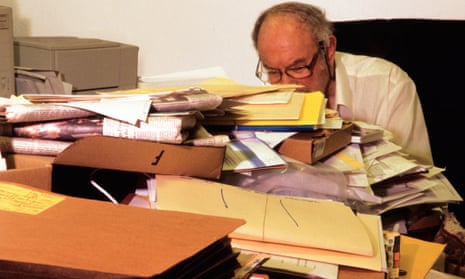 Man reads desk full of legal documents.