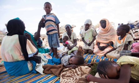 A group of women and children shelter at the Kalma camp for internally displaced people in South Darfur.