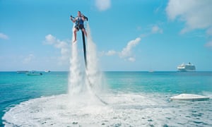 An employee of Jetpack Cayman is propelled up out of the sea by a motor pumping water into a jetpack