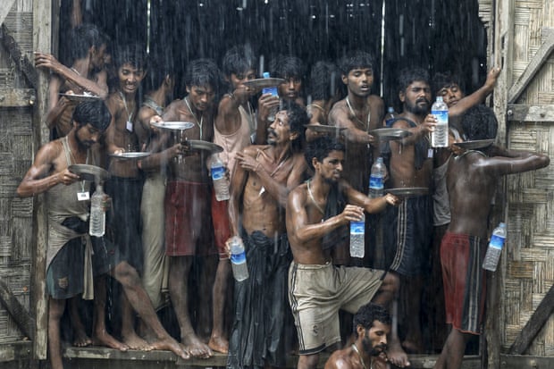Migrants, who were found at sea on a boat, collect rainwater at a temporary refugee camp in northern Rakhine state, Burma, 4 June 2015.