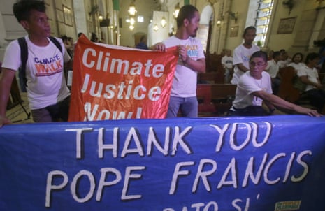 Environmental activists display a banner as they prepare to listen to speeches inside a Roman Catholic church to coincide with Pope Francis' encyclical on climate change Thursday, June 18, 2015 in Manila, Philippines. In a high-level, 190-page document released Thursday, Francis  describes ongoing human damage to nature as "one small sign of the ethical, cultural and spiritual crisis of modernity." The solution, he says, will require self-sacrifice and a "bold cultural revolution" worldwide.